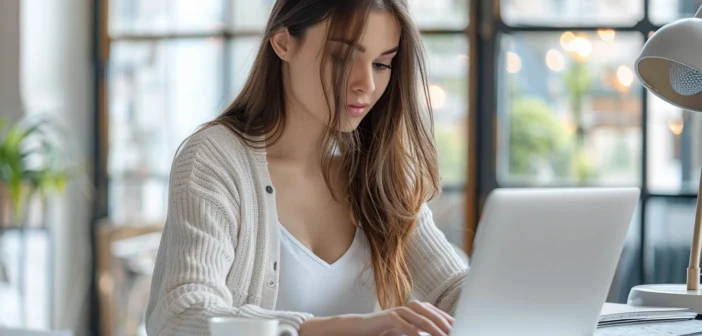 A lifestyle stock photography of a young professional woman sitting at a modern home office desk, focused and engaged in an online learning session on her laptop, surrounded by neatly organized study materials and a cup of coffee; the scene is set in a bright, airy room with large windows letting in natural daylight; the composition includes a clean, minimalist design with soft, natural lighting to create a serene and productive atmosphere; the framing captures her from a slightly elevated angle to show both her concentration and the inviting workspace; the overall mood is one of motivation and efficiency. --ar 3:2 --no text, fonts, letters, watermark, words, typography, slogans, signature, camera --v 6.0 --s 250